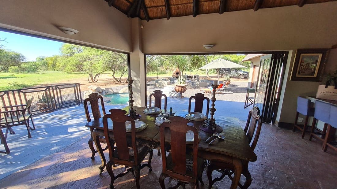 Thatched lodge dining area overlooking the pool and bushveld at Swa-Zulu